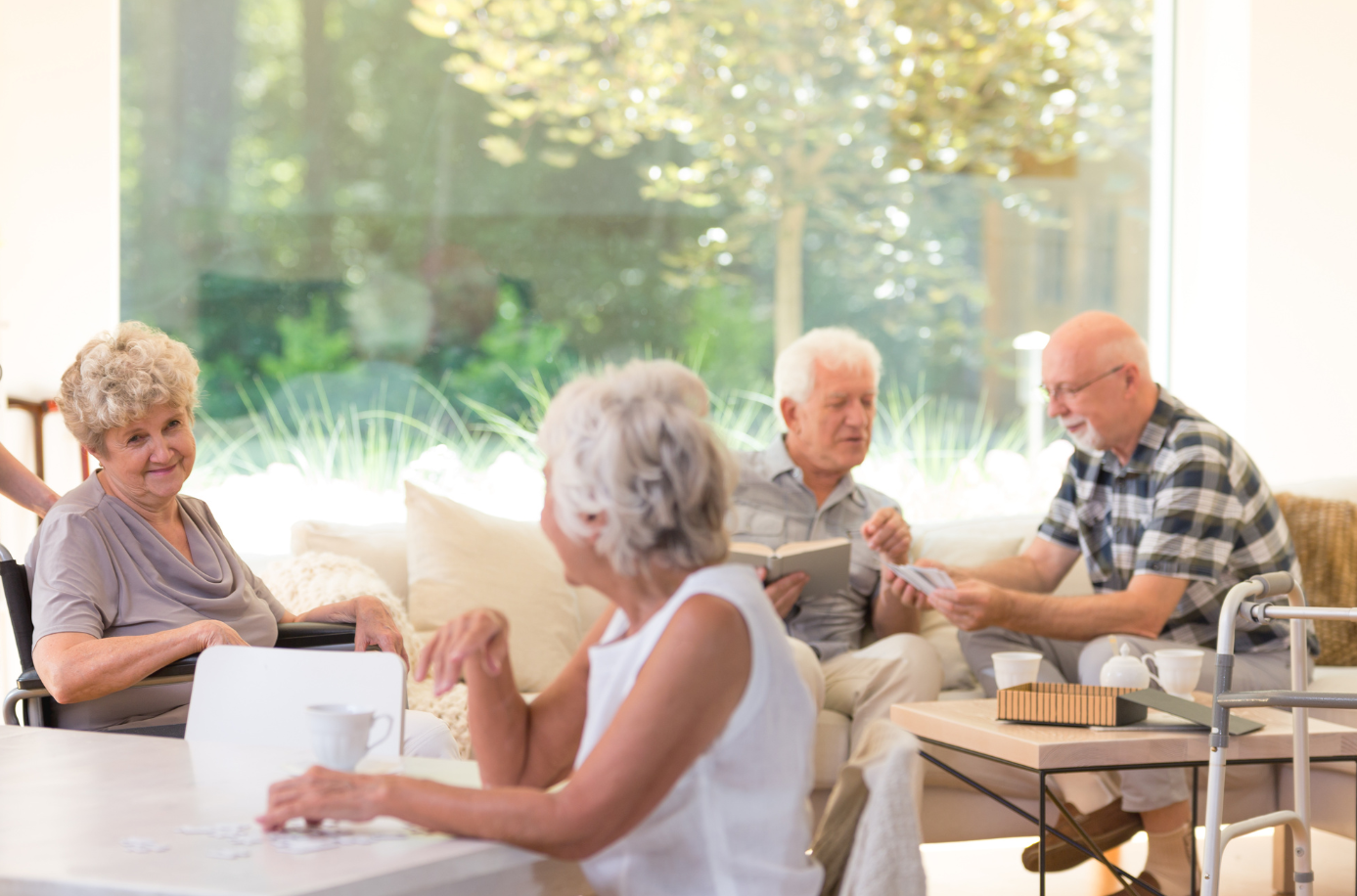 Seniors socializing in a bright, comfortable common area at Greenleaf Court Senior Living